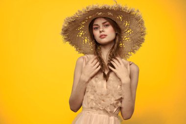 Şapkalı ve elbiseli bir bayan. Kızıl saçlı, sarı arka planlı, model portresi eğlenceli.