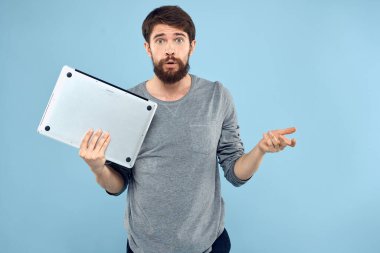 Sakallı adam dizüstü bilgisayarı elinde internet kablosuz teknoloji duyguları mavi arka plan