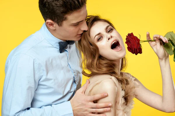 Szerelmes férfi és nő vörös rózsa sárga háttér vágott kilátás közelkép romantika — Stock Fotó