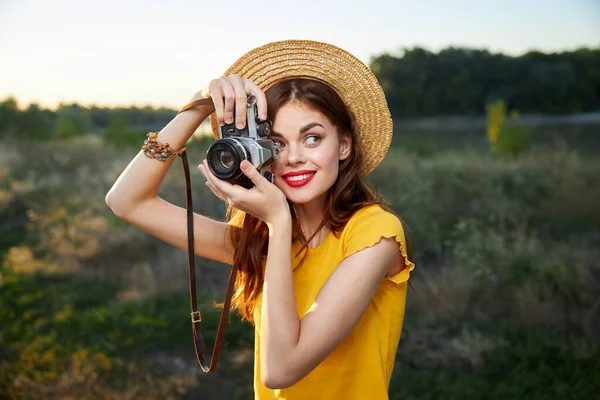 Fotografer wanita memegang kamera di dekat wajah melihat ke samping senyum alam — Stok Foto