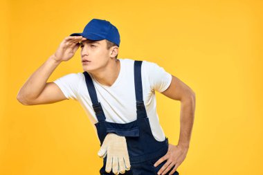 Çalışan üniformalı adam duygularını servis hizmeti sarı arka planda sunuyor