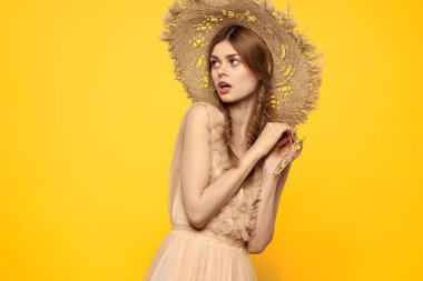 Şapkalı ve elbiseli bir bayan. Kızıl saçlı, sarı arka planlı, model portresi eğlenceli.