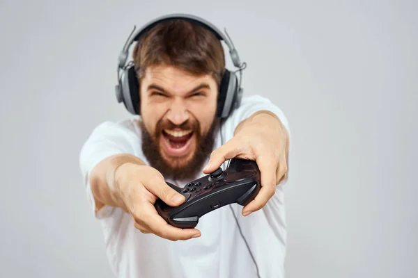 Hombre en auriculares con gamepad jugando hobby entretenimiento estilo de vida luz fondo —  Fotos de Stock