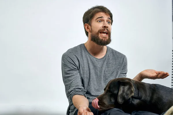 Feliz propietario con mascota negro perro entrenamiento modelo emociones — Foto de Stock