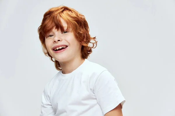 Vrolijke roodharige jongen glimlach wit t-shirt bijgesneden uitzicht grijs — Stockfoto