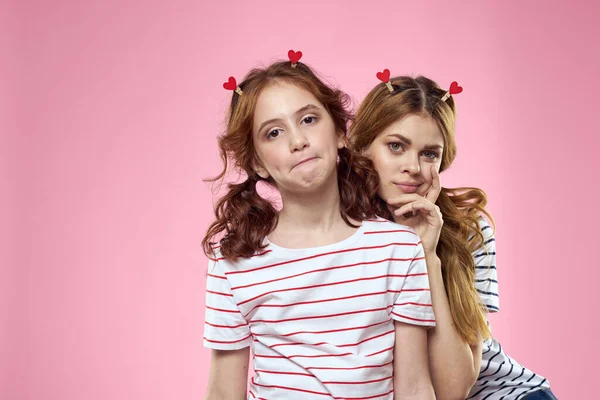 Alegre mamá e hija estilo de vida alegría rayas camisas familia rosa fondo — Foto de Stock