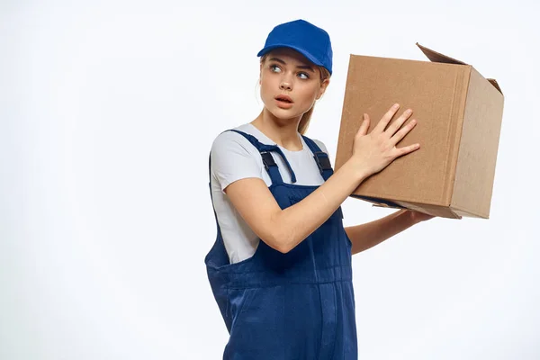 Woman working uniform box in hands packing service light background — Stock Photo, Image
