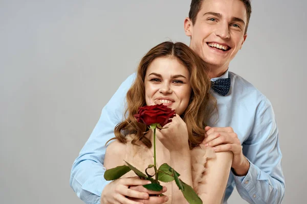 Young couple hugs romance dating lifestyle relationship light background red rose — Stock Photo, Image