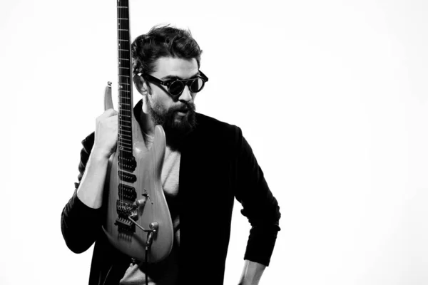 Ein Mann mit einer Gitarre Emotionen Musik Spiel Leistung Lederjacke Sonnenbrille heller Hintergrund — Stockfoto