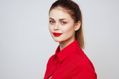 Açık arkaplanda kırmızı dudaklı bir kadının portresi. Makyaj modeli.