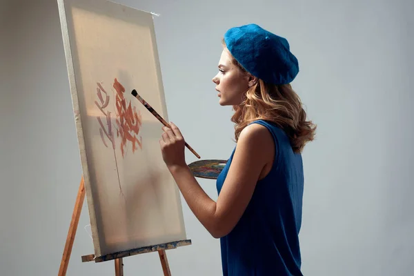 Женщина художник в голубой беретной палитре мольберт рисования искусства творческого хобби серый фон — стоковое фото