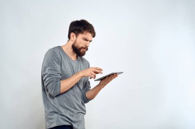 Elinde tablet, elinde internet teknolojisi olan bir adam. İletişim teknolojisi. Gri ceketli.