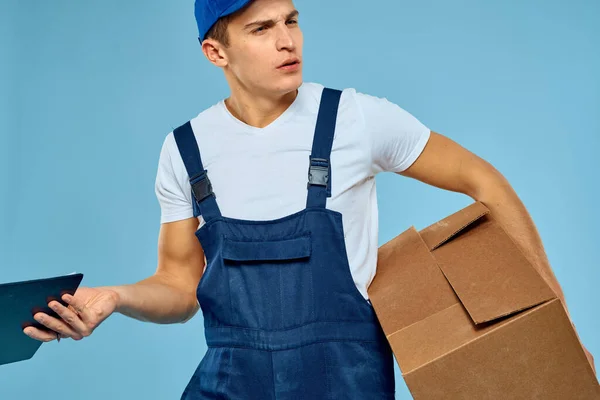 Hombre trabajador con caja de cartón entrega cargador estilo de vida fondo azul — Foto de Stock