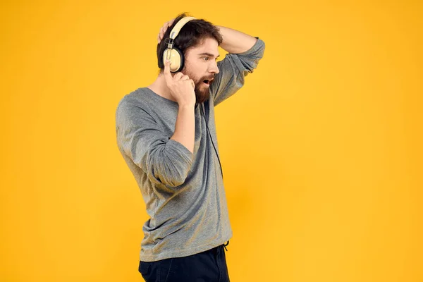 Hombre con auriculares música estilo de vida estilo de vida tecnología fondo amarillo —  Fotos de Stock