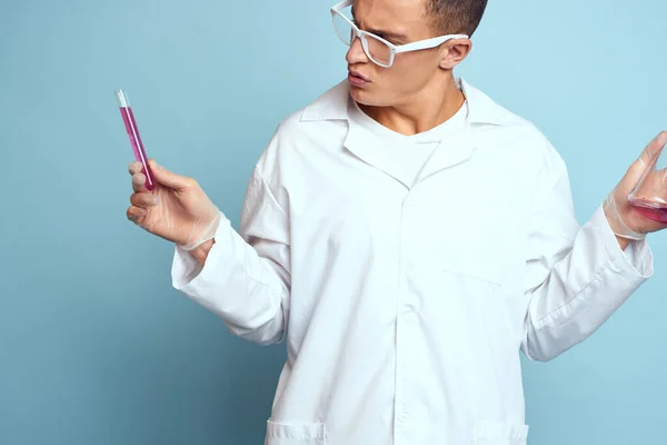 Homme tenant des flacons coloré liquide chimique modèle de laboratoire portant des lunettes — Photo