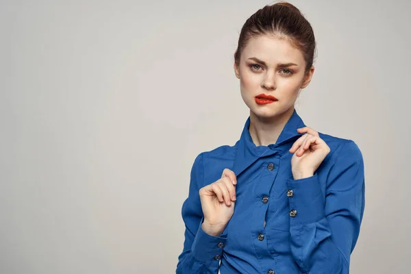 Retrato de una hermosa mujer con labios rojos sobre un fondo claro y una camisa azul vista recortada — Foto de Stock
