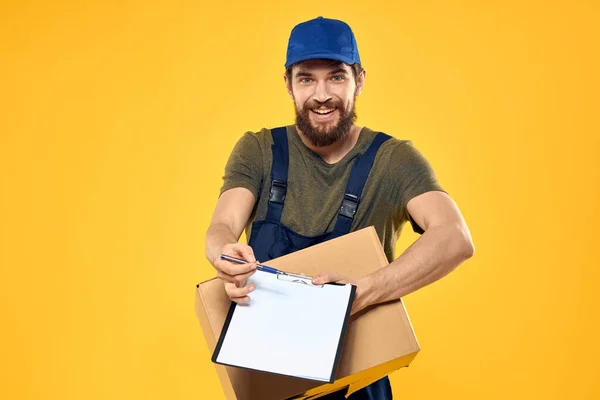 Worker male courier delivering boxes packaging documents yellow background