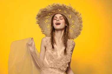 Sarı arkaplan duygularıyla elinde hasır şapkalı bir kadın... 