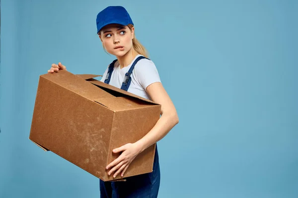 Женщина рабочая форма поле в руках упаковки службы доставки синий фон — стоковое фото