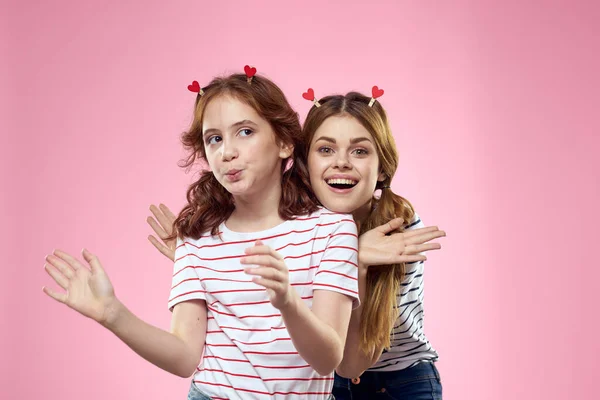 Alegre mãe e filha alegria estilo de vida estúdio rosa fundo família — Fotografia de Stock