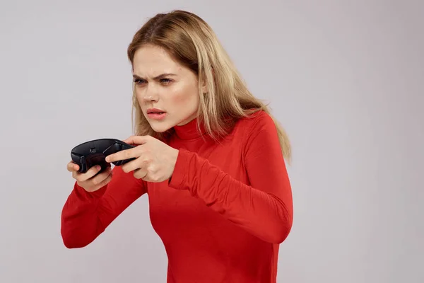 Жінка з геймпад в руках грає в ігри емоції спосіб життя дозвілля червона сорочка світлий фон — стокове фото