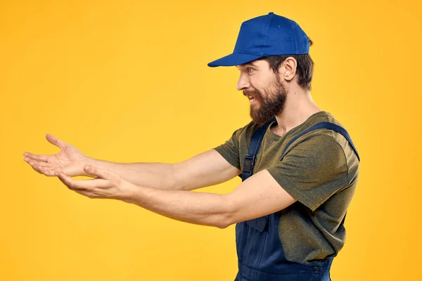 Lavoratore uomo in uniforme lavoratore servizio giallo sfondo emozione — Foto Stock