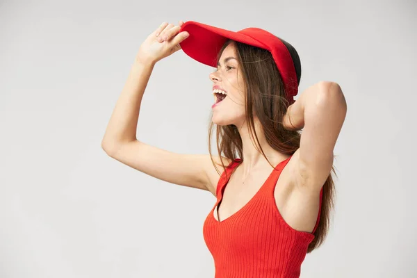 Cheerful woman with open mouth looking to the side cap on head red t-shirt — Stock Photo, Image