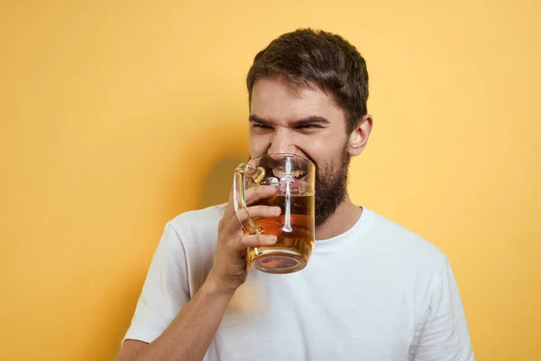 Homme avec une tasse de bière sur un fond jaune blanc t-shirt émotions Espace de copie — Photo