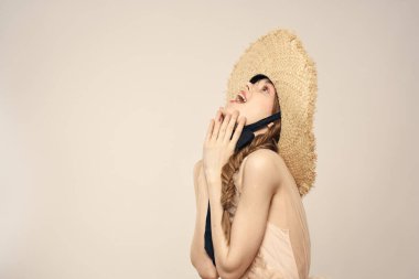 Şapkalı ve arka planda giyinmiş romantik bir kadın elleriyle komik duyguların portresini çiziyor.