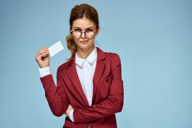 İş kadını kırmızı ceketli, gözlüklü, yönetici mavi arka planlı.