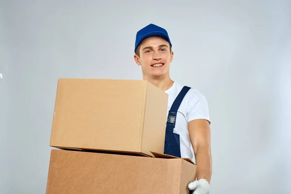 Lavoratore uomo in uniforme con scatole nelle sue mani consegna caricatore stile di vita — Foto Stock