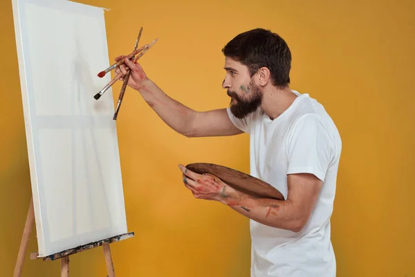 취미 생활의 창의성을 노란 배경으로 그린 남성 미술가 팔레트 이젤 — 스톡 사진