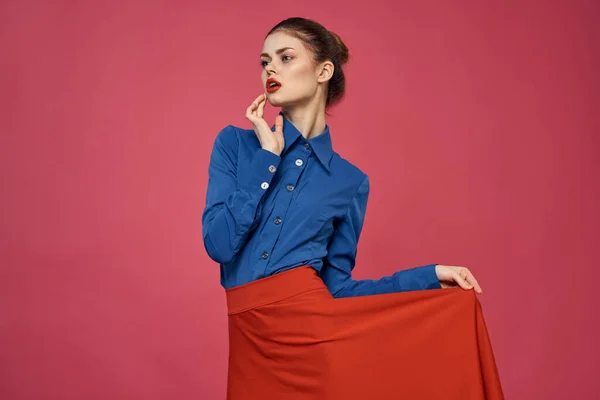 Mujer en camisa azul y cubos rojos sobre fondo rosa emociones divertidas modelo recortado ver — Foto de Stock