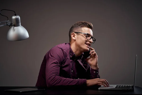 Gerente do sexo masculino está sentado à mesa e falando no telefone aberto laptop trabalhando sala de escritório — Fotografia de Stock
