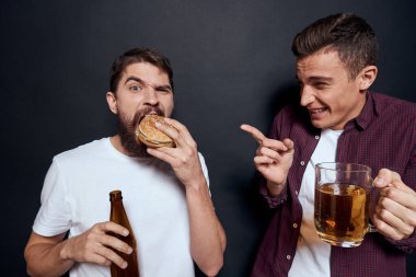 Bira içen iki sarhoş arkadaş dinleniyor. Geçmişi karanlık.