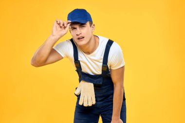Eldivenli işçi üniforması içinde servis sarı arka planda.