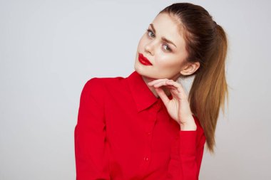 Açık arkaplanda kırmızı dudaklı bir kadının portresi. Makyaj modeli.