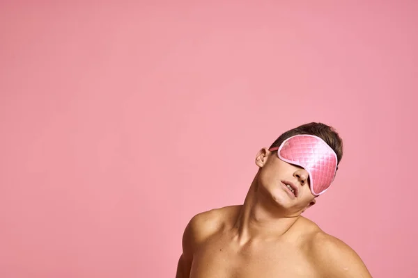 男でピンクの睡眠マスクでピンクの背景裸の肩の朝 — ストック写真