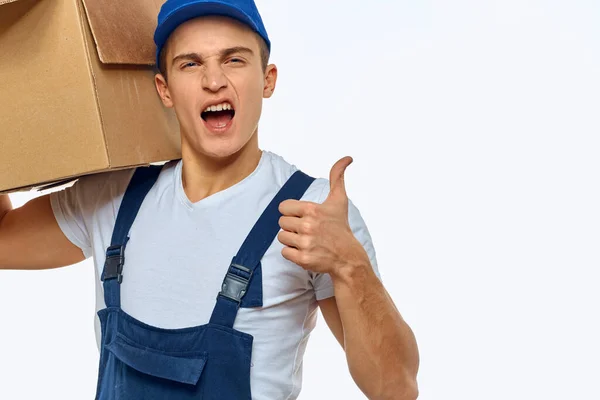 Ein Mann in Arbeitsuniform mit einem Karton in der Hand belädt einen Lieferdienst — Stockfoto