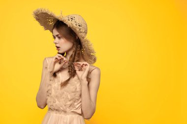 Şapkalı ve elbiseli bir bayan. Kızıl saçlı, sarı arka planlı, model portresi eğlenceli.