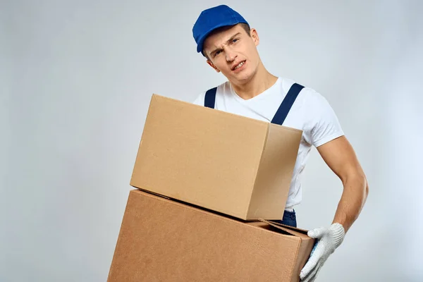 Pracujący mężczyzna w mundurze z pudełkami w ręku dostawy styl życia ładowarki — Zdjęcie stockowe