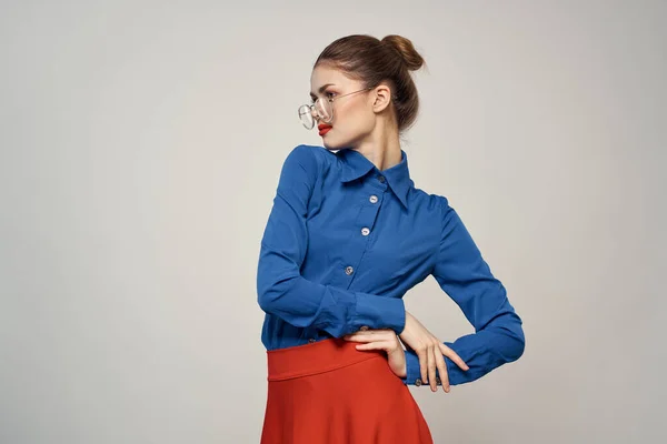 Vrouw model in blauw shirt en rode rok bril mooi gezicht make-up studio — Stockfoto