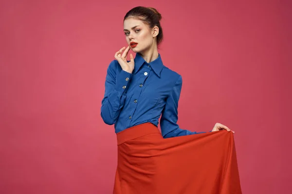 Mujer en camisa azul y cubos rojos sobre fondo rosa emociones divertidas modelo recortado ver — Foto de Stock