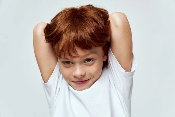 Lindo chico manos detrás de la cabeza sonrisa blanco camiseta estudio gris fondo — Foto de Stock