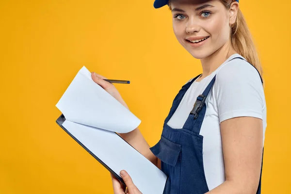 Женщина в рабочей форме документы курьера службы желтый фон — стоковое фото