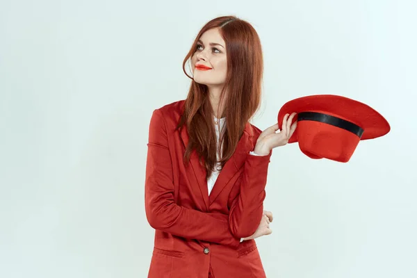 Elegante vrouw in rode jas hoed met lang haar bijgesneden lichte achtergrond — Stockfoto