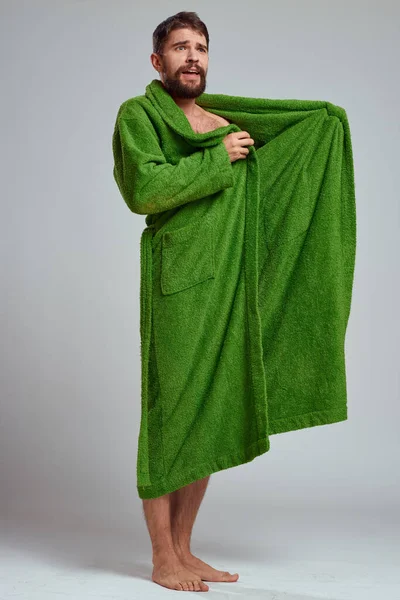 Uomo emotivo in vestaglia verde su uno sfondo chiaro in piena crescita divertente modello di emozioni — Foto Stock