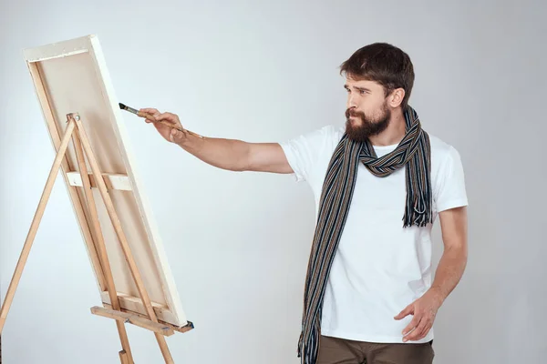 Ein Mann Künstler zeichnet auf einer Staffelei einen Schal weißes T-Shirt Kunst Hobby Kreativität — Stockfoto