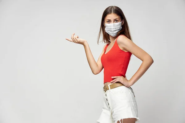 Mulher em máscara protetora contra coronavírus posando em estúdio. — Fotografia de Stock