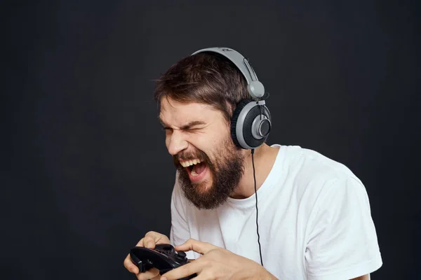 Man in hoofdtelefoon met gamepad leuke entertainment games lifestyle donkere achtergrond — Stockfoto